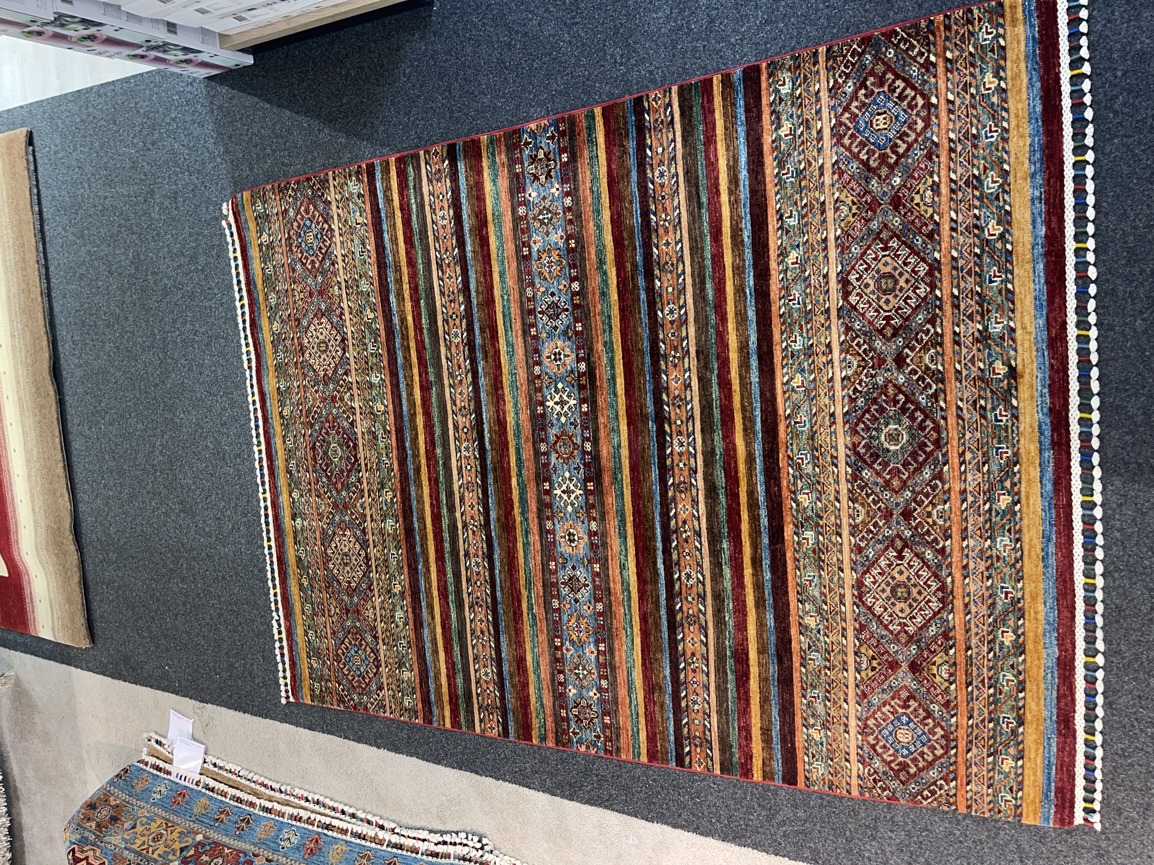 Gila Teppich Samarkand in rot/bunt, ca. 200x148 cm, mit geometrischen Mustern und Fransen.