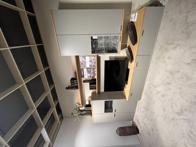 Wohnwand Venue in Platingrau mit Eiche sand, bestehend aus TV-Element, Regalen und Vitrine.