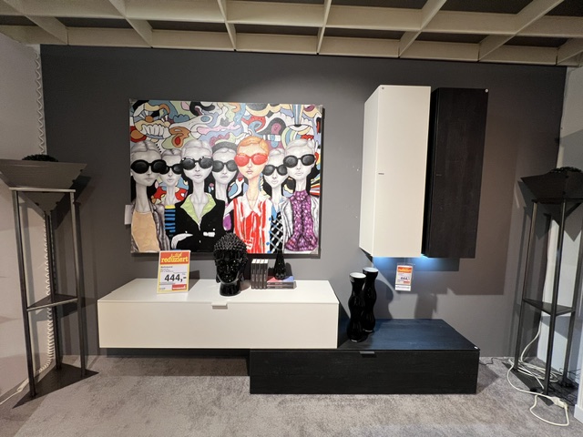 Wohnwand in Weiß matt lackiert, ca. 200x200x42 cm, mit dekorativem Wandbild und Ausstellungsstück.
