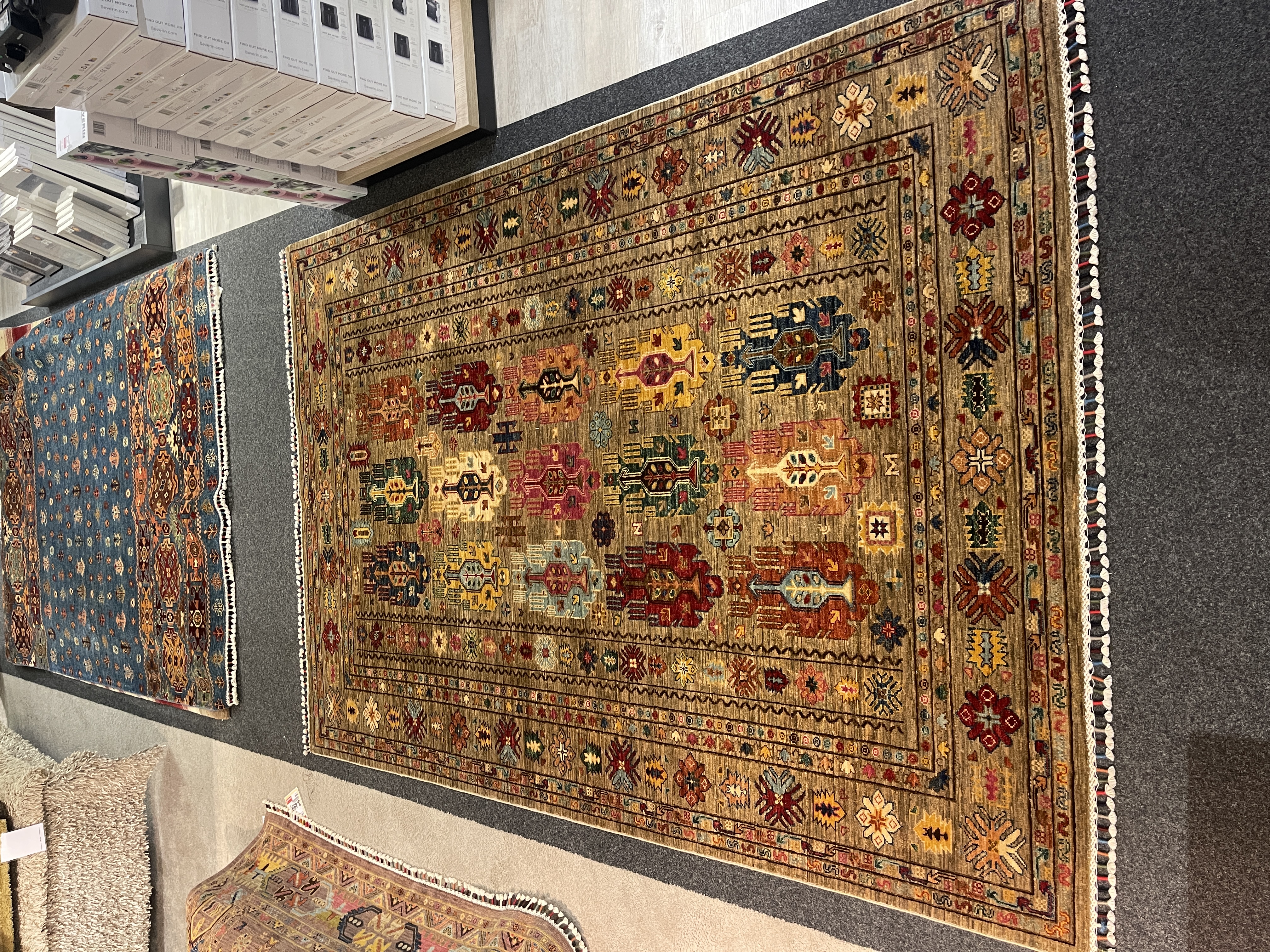 Gila Teppich in Grau, ca. 251x176 cm, mit bunten, geometrischen Mustern und Fransen.