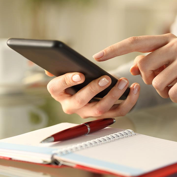 Jemand hält ein Handy in der Hand auf dem ein Beratungstermin gebucht wird