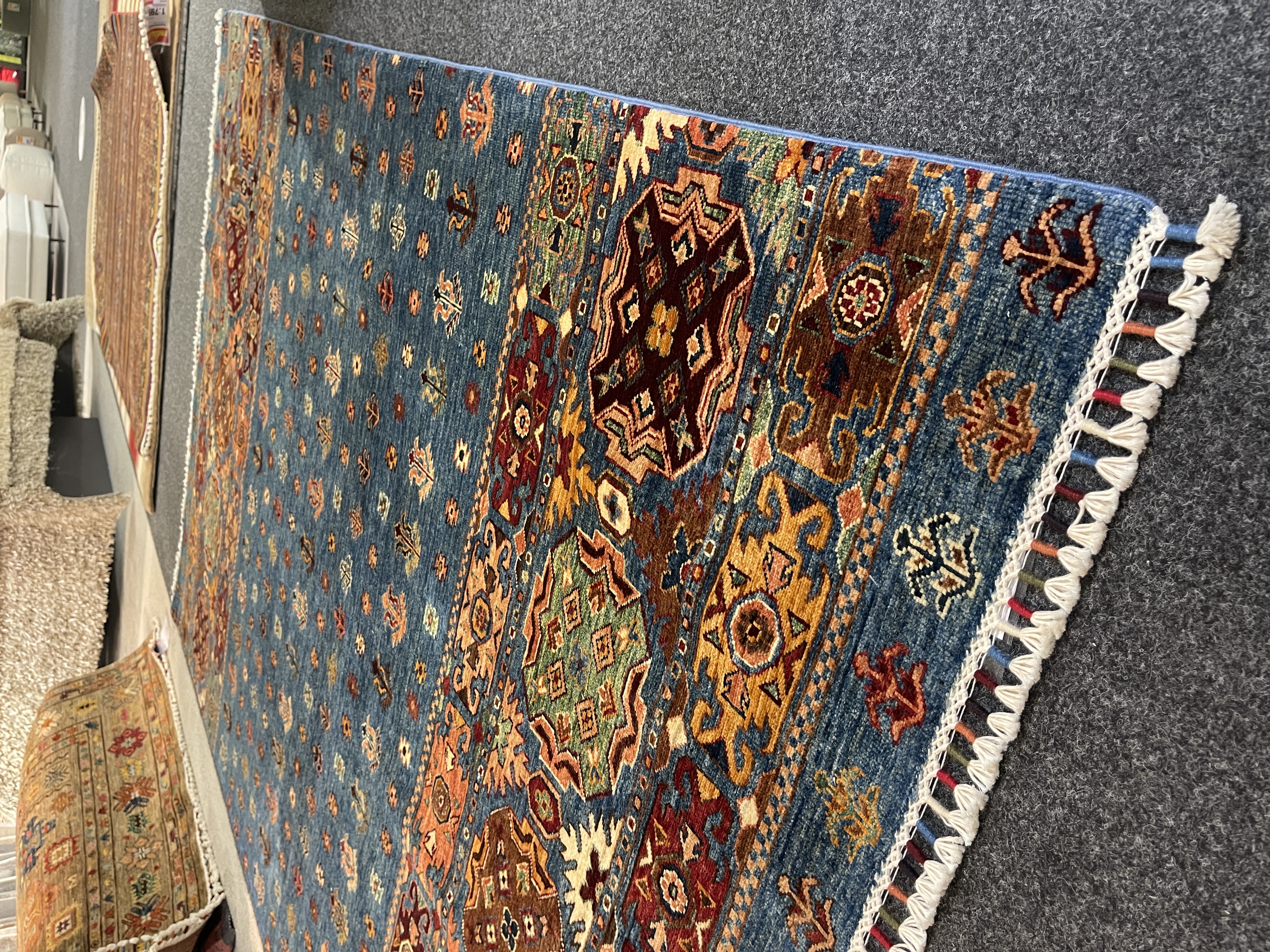 Gila Teppich Khamsehbaft in Blau/Multicolor, ca. 250x176 cm, mit buntem, geometrischem Muster und Fransen.