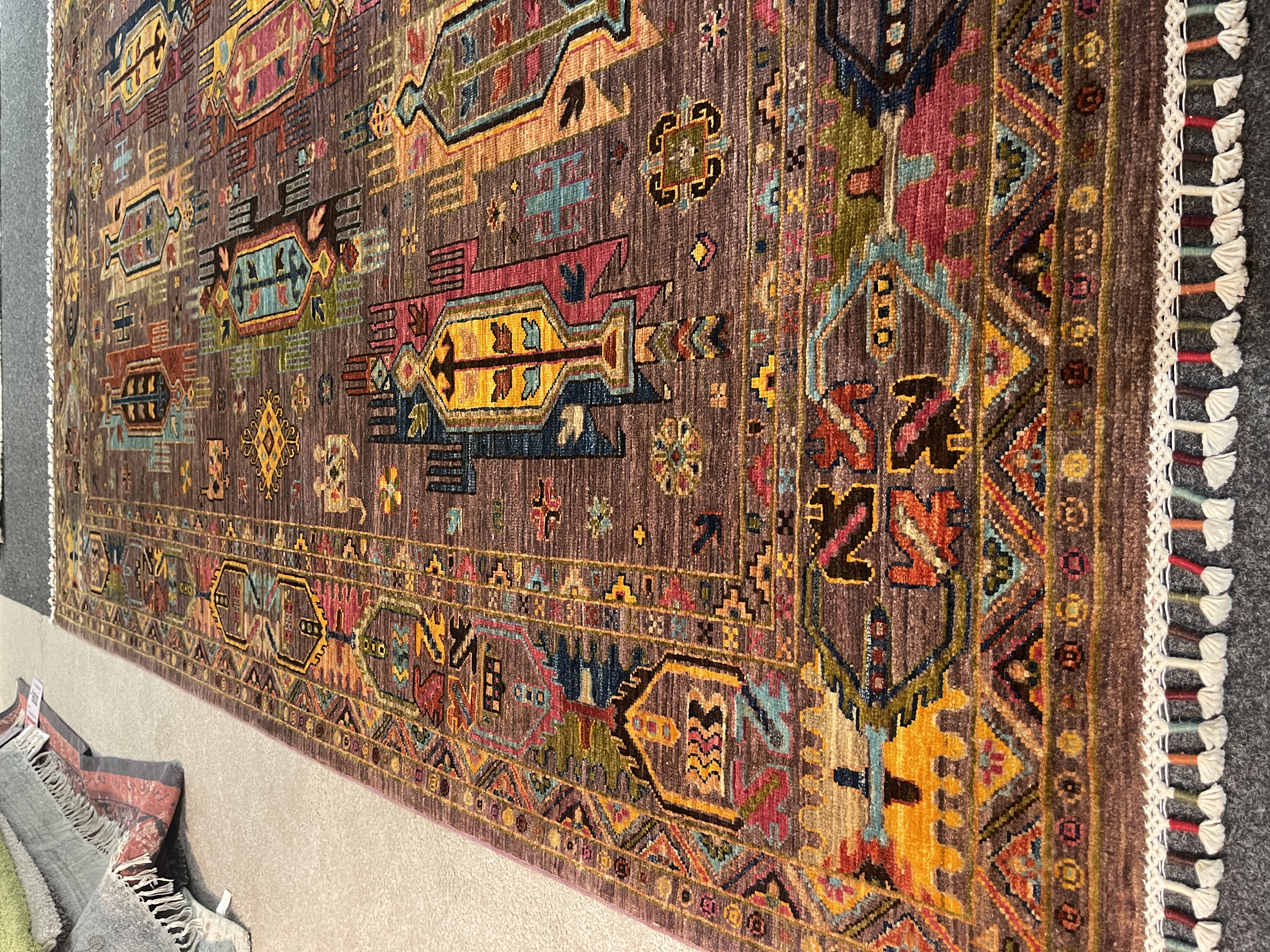 Gila Teppich in Braun mit bunten, geometrischen Mustern und Fransen, Größe ca. 258x175 cm.