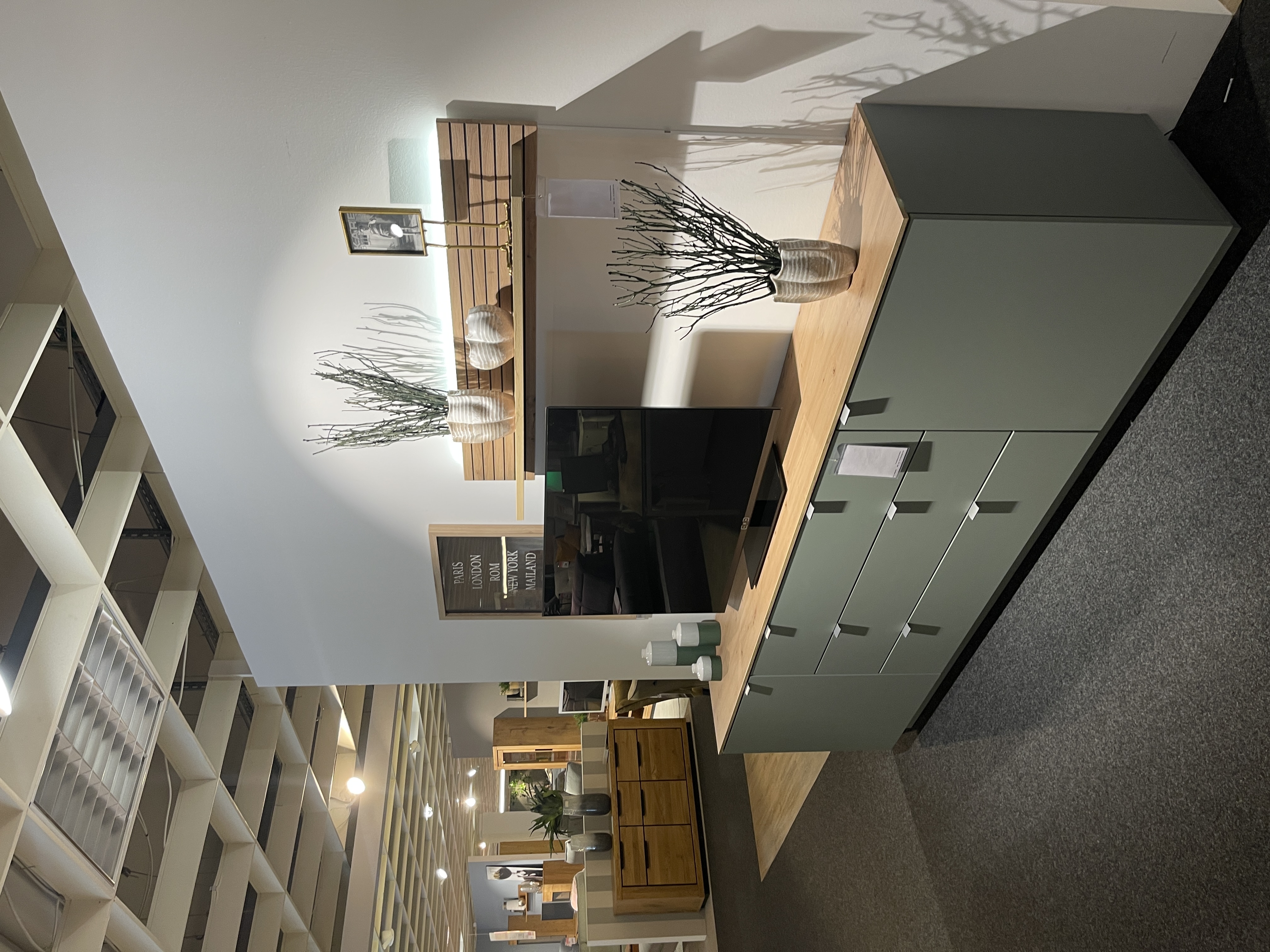 Wandboard Core aus Artisan Eiche mit Rillenoptik und Beleuchtung, montiert über einer modernen Kommode.