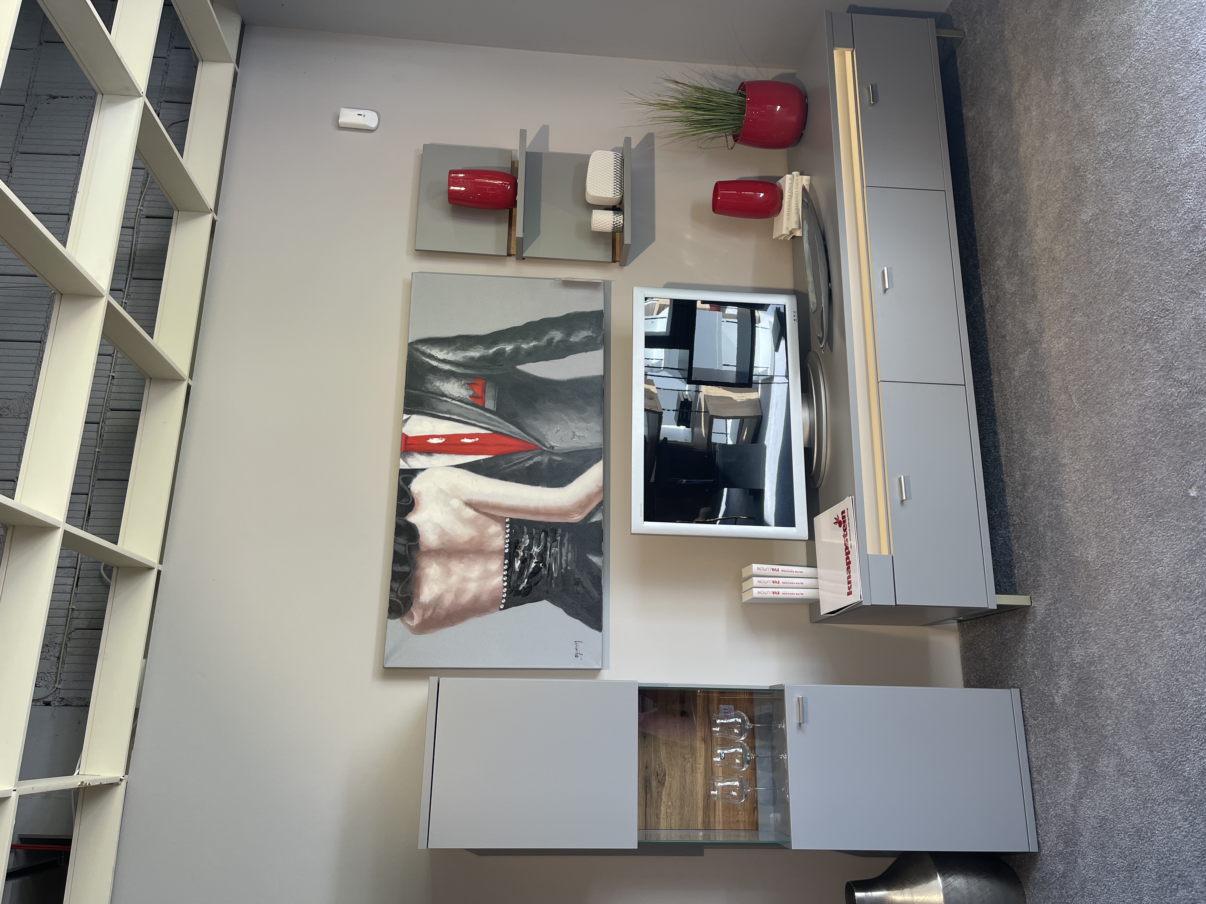 Wohnwand Marseille in Grau mit Wildeiche-Dekor, bestehend aus TV-Element, Vitrine und Regalen, dekoriert mit roten Accesso...