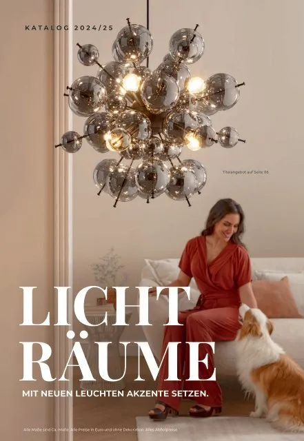 LEUCHTEN - Licht Räume 2024/2025 Frau in rotem Kleid sitzt auf einer Couch neben einem Hund, beleuchtet von einer modernen, kugelförmigen Deckenleuchte.